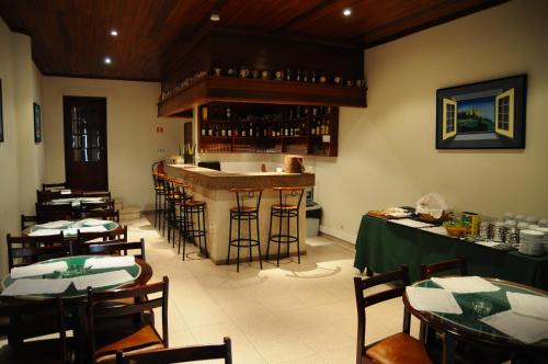 アルカセル・ド・サルにあるHotel A Cegonhaのバー付きのレストラン、テーブルと椅子