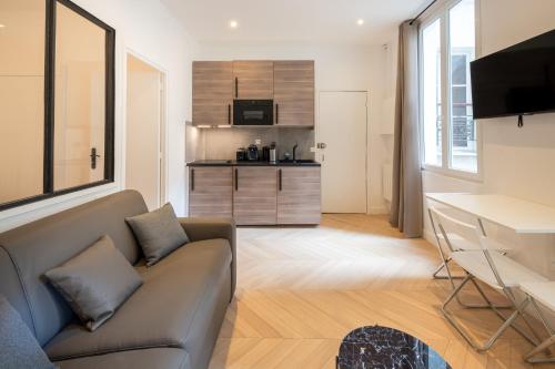 un salon avec un canapé et un bureau dans l'établissement APPARTEMENT CONTEMPORAIN RÉPUBLIQUE - TEMPLE, à Paris