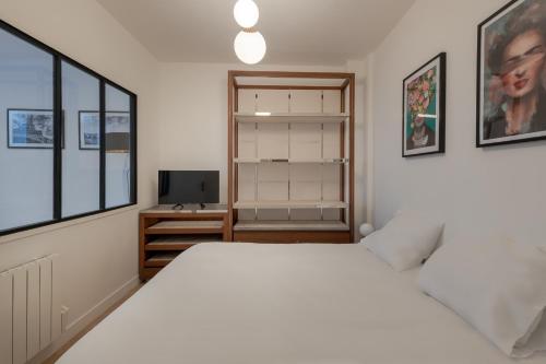 une chambre avec un lit blanc et un bureau dans l'établissement APPARTEMENT CONTEMPORAIN RÉPUBLIQUE - TEMPLE, à Paris
