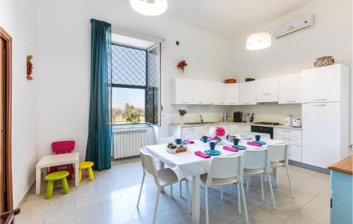 a white kitchen with a table and chairs in a room at Casa Sul Mare in Castellammare di Stabia