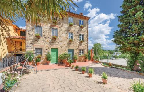 un bâtiment en pierre avec des plantes en pot devant lui dans l'établissement Corte Pasquini, à San Ginese