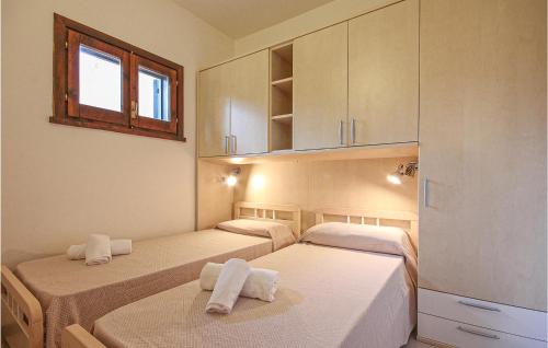 モンテ・ナイにあるAwesome Apartment In Costa Rei -ca- With 2 Bedrooms And Wifiのベッド3台とキャビネット付きの部屋