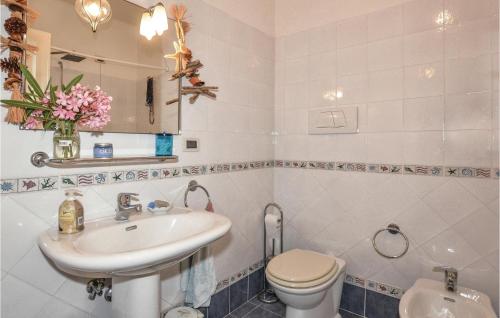 a white bathroom with a sink and a toilet at Casa Pescaia in Castiglione della Pescaia