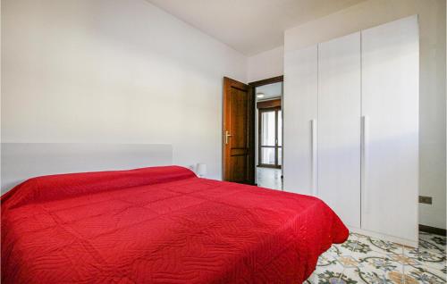 Dormitorio blanco con cama roja y armario en Bilo 1, en Alba Adriatica