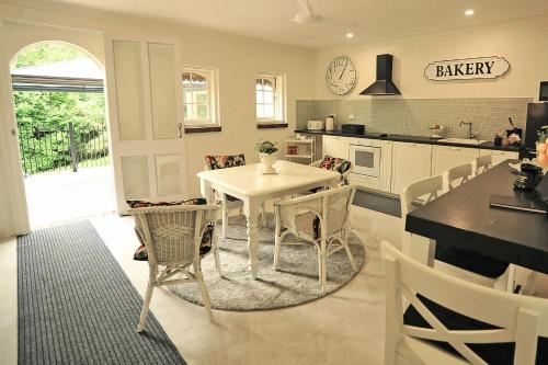 Belle Vue Park Villa في جبل تامبورين: مطبخ مع طاولة بيضاء وكراسي