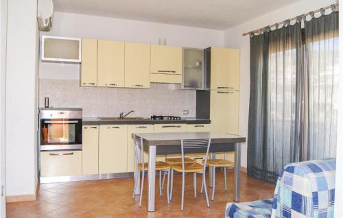 カステルサルドにあるIbiscus Trilo 9の白いキャビネット、テーブルと椅子付きのキッチンが備わります。
