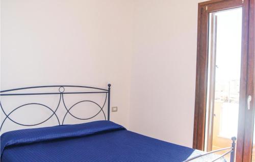 a bedroom with a blue bed and a window at Ibiscus Trilo 9 in Castelsardo