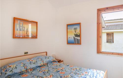 een slaapkamer met een bed en twee foto's aan de muur bij 1 Bedroom Awesome Apartment In Botricello in Botricello