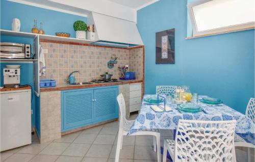 a kitchen with a table and a kitchen with blue walls at Nice Home In Scoglitti With Wifi in Scoglitti