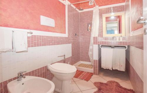 a bathroom with a white toilet and a sink at Nice Home In Scoglitti With Wifi in Scoglitti