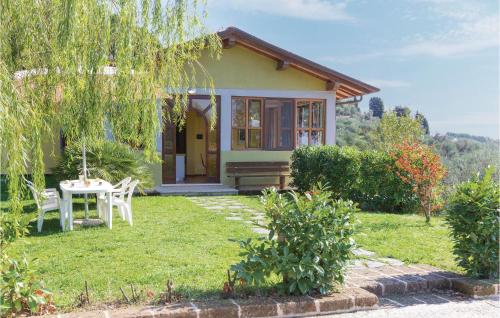 a small yellow house with a table in the yard at Villa 1 in Corsanico-Bargecchia