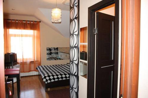 Habitación con cama, ventana y puerta en Guest house Svetlana en Gorno-Altaisk