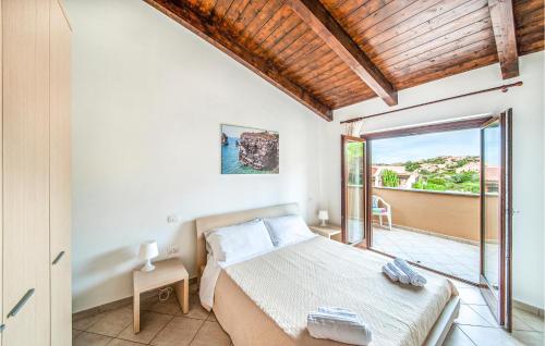 a bedroom with a bed and a balcony at Awesome Apartment In Trinitadagultu Ot With Kitchen in Trinità d'Agultu e Vignola