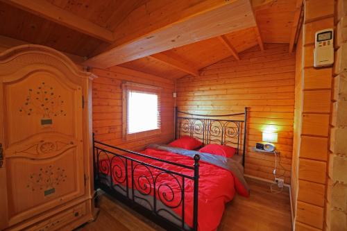 a bedroom with a bed in a log cabin at La Lavande in Camaret-sur-Aigues