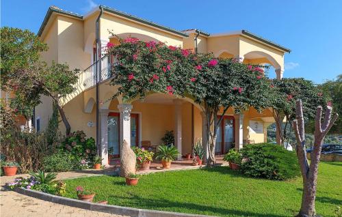 a large house with flowers on the front yard at Mono 2 in Badesi