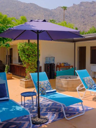 two chairs and an umbrella on a patio at Old Ranch Inn - Adults Only 21 & Up in Palm Springs