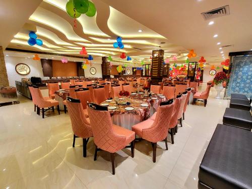 a banquet hall with tables and chairs in a restaurant at Hotel Makhan Residency in Amritsar