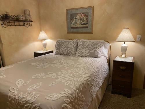 a bedroom with a bed and two night stands with lamps at River Falls Lodging -Black Hills, South Dakota in Hot Springs
