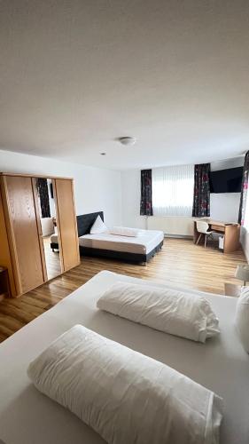 a large bedroom with two beds and a desk at Hotel am Kirschberg in Alten Buseck