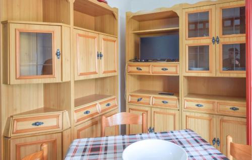 eine Küche mit Holzschränken, einem Tisch und einem TV in der Unterkunft 2 Bedroom Cozy Apartment In Botricello in Botricello