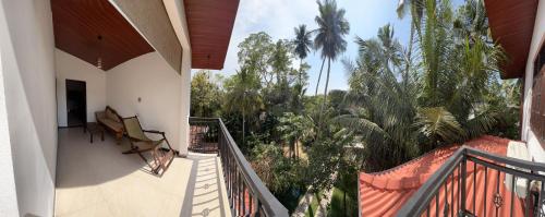 a balcony of a house with palm trees at Tanzanite place in Tangalle