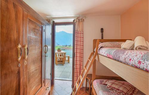 - une chambre avec des lits superposés et une porte donnant sur un balcon dans l'établissement Casa Meno, à Novate Mezzola