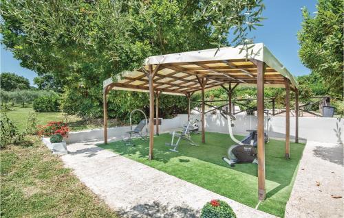 a wooden pergola with chairs under it in a yard at Beautiful Home In Acquasparta -Tr- in Configni