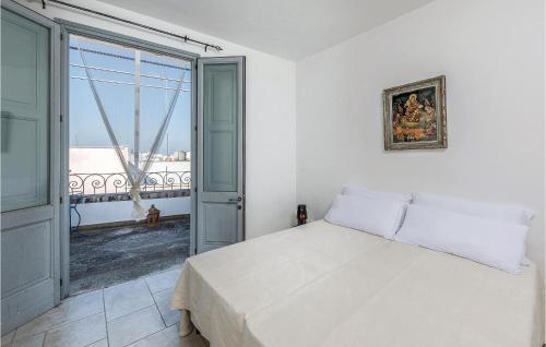 ein weißes Schlafzimmer mit einem Bett und einem großen Fenster in der Unterkunft La Casa Di Marina 2 in Marittima