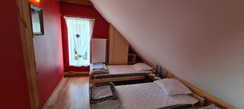 a small room with two beds and a window at Apartament Kazimierza Wielkiego in Sośnica