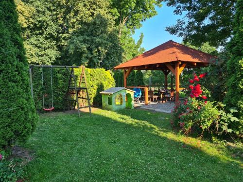 a gazebo with a swing and a playground at Apartament Kazimierza Wielkiego in Sośnica