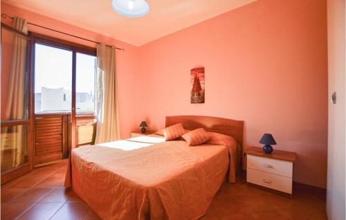 una camera da letto con un letto con lenzuola arancioni e una finestra di Appartamento Clizia 2 a Marinella di Selinunte