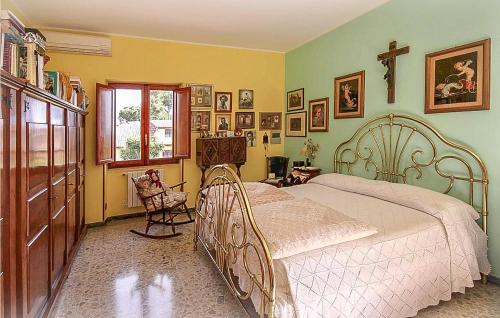 ein Schlafzimmer mit einem Bett und einem Kreuz an der Wand in der Unterkunft Gorgeous Home In Ardea With House A Panoramic View in Ardea