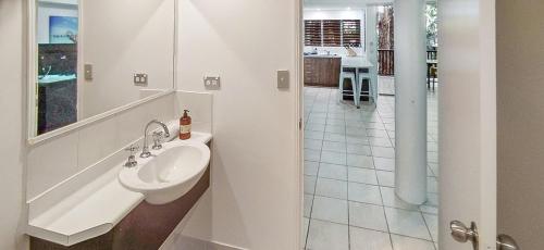 a white bathroom with a sink and a shower at REEF RETREAT APARTMENTS PALM COVE Unit 13 in Palm Cove