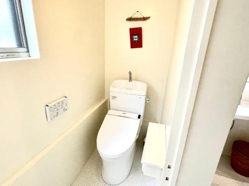 a bathroom with a white toilet in a room at Megijima Beach Apartment in Takamatsu