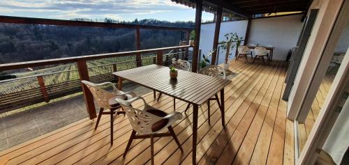 a wooden deck with a table and chairs on a balcony at Weingut & Ferienwohnungen Lenhard in Lang