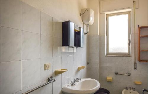 bagno bianco con lavandino e specchio di 2 Bedroom Lovely Apartment In Sellia Marina a Sellia Marina