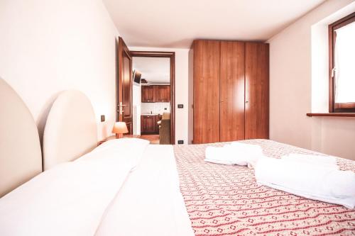 a bedroom with a large bed with white sheets at Residence Aquila - Bilo Punta Goà in Brusson