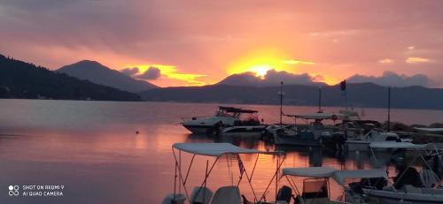 a group of boats docked at a dock with a sunset at Aliki Studios in Boukari