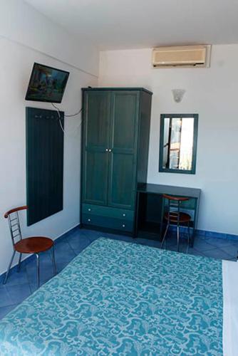 a bedroom with green cabinets and a table and chairs at Hotel Residence La Darsena in Agropoli