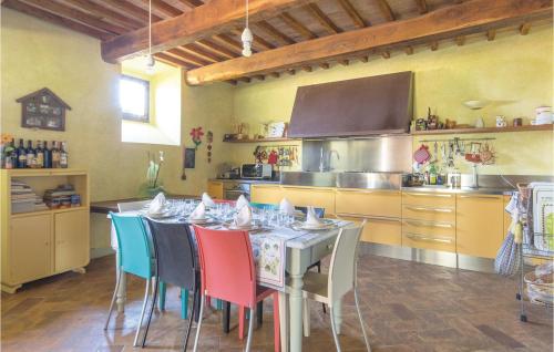 a kitchen with a table with colorful chairs in it at Podere Case Sparse in Citerna
