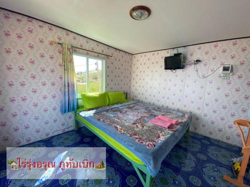 a bedroom with a bed in a room with wallpaper at ไร่รุ่งอรุณ ภูทับเบิก in Ban Maeo Thap Boek