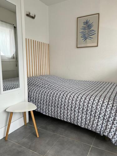 um quarto com uma cama, uma mesa e um espelho em Charmant studio, centre-ville em Auxerre