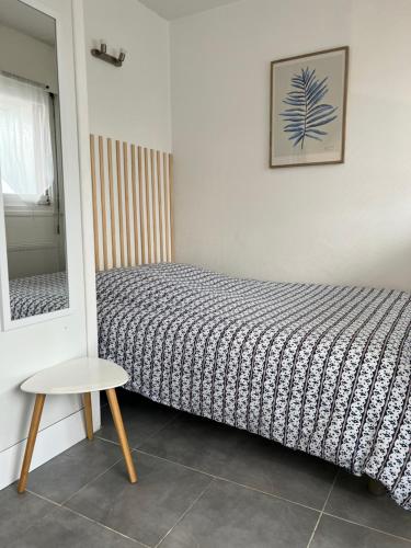 une chambre avec un lit, une table et un miroir dans l'établissement Charmant studio, centre-ville, à Auxerre