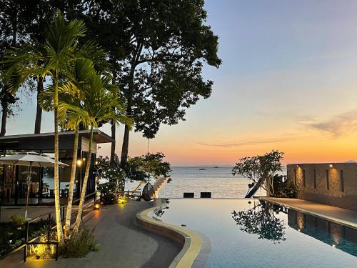 uma piscina de resort com o oceano ao fundo em Blue Orchid Beach Krabi - SHA Certified em Ao Nam Mao