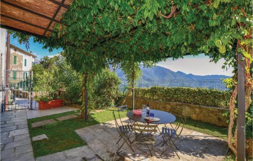 a patio with a table and chairs under a tree at Riccio in Piano di Mommio