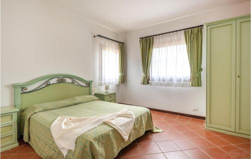 a bedroom with a green bed and two windows at Villa 4 in Stintino