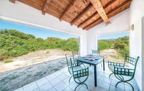 ein Esszimmer mit einem Tisch und Stühlen auf einer Terrasse in der Unterkunft Mare Dei Ginepri Bilocale in Badesi