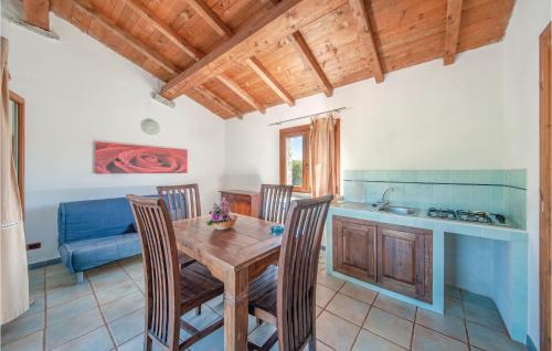 eine Küche und ein Esszimmer mit einem Holztisch und Stühlen in der Unterkunft Mare Dei Ginepri Bilocale in Badesi