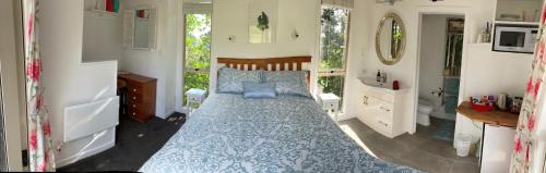 a bedroom with a bed with a blue comforter at The Treehut in Ohauiti