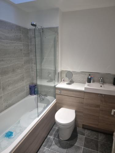 La salle de bains est pourvue de toilettes, d'une baignoire et d'un lavabo. dans l'établissement Impeccable Beachfront 2-Bed Cottage in St Bees, à St Bees